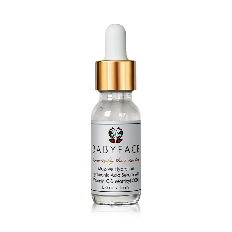 May include: A clear glass bottle with a gold cap and dropper, containing a hyaluronic acid serum with vitamin C and Matrixyl 3000. The bottle is labeled "BABYFACE Superior Quality Skin & Hair Care Massive Hydration Hyaluronic Acid Serum with Vitamin C & Matrixyl 3000 0.6 oz. / 18 ml."