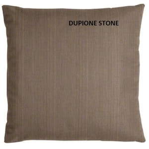 May include: A brown throw pillow with a textured fabric. The pillow has the text "DUPIONE STONE" printed on it.