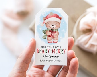 May include: A Christmas gift tag featuring a watercolor illustration of a teddy bear wearing a Santa hat and scarf, holding a wrapped present. The tag reads "Hope you have a Beary-Merry Christmas" with a personalized name.