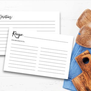 May include: Two blank recipe cards with lined spaces for writing down ingredients and directions. The cards are white with black lines and text.