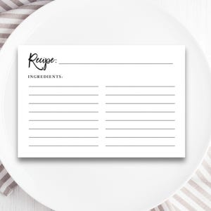 May include: A blank white recipe card with the word "Recipe" written in cursive at the top and the word "Ingredients" written below it. The card has lines for writing down the recipe and ingredients.