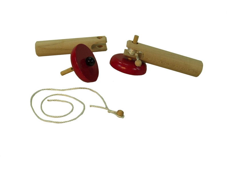 May include: Two wooden spinning tops with red tops and a string for winding them up.