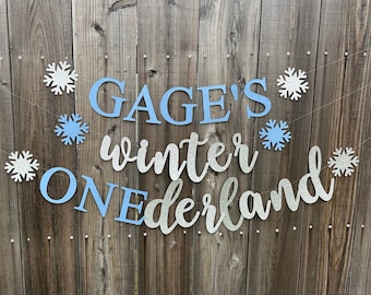 May include: A blue and silver glitter banner with the text "Gage's Winter Wonderland" and snowflake decorations.