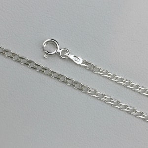 May include: A silver curb chain necklace with a lobster clasp.