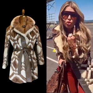 May include: A vintage fur coat with a geometric pattern in shades of brown and white. The coat features a wide collar, a brown leather belt, and a classic silhouette. The coat is displayed on a mannequin.