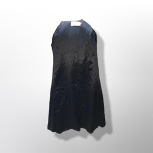 May include: A black coat interior with a dark lining. The coat is open, revealing the inside lining. A small white tag is visible at the top. The coat is hanging against a white background.