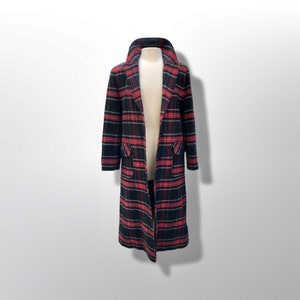 May include: A long, open coat with a classic plaid pattern in black, red, and gray. The coat features a notched collar, two front pockets, and a knee-length hem. The coat is displayed on a mannequin.