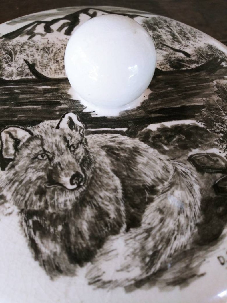 Vintage Mid Century Alaskan Art by Bering Sea Originals featuring a Wolf in a woodland scene on a round ceramic covered trinket box