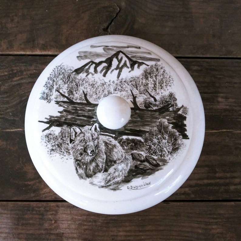 Vintage Mid Century Alaskan Art by Bering Sea Originals featuring a Wolf in a woodland scene on a round ceramic covered trinket box