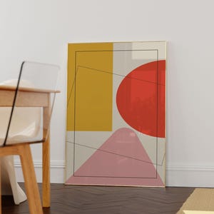May include: A framed rectangular wall art print featuring a composition of a mustard yellow rectangle, a large red semi-circle, and a pink triangular shape on a light gray background, overlaid with thin black geometric line drawings.