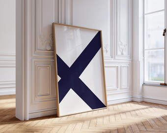 May include: A framed art print with a white backdrop and a bold navy blue X. The artwork is displayed in a room with white walls, a wooden floor, and a window. The frame is a light brown colour.