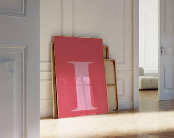 以下が含まれることがあります： 鮮やかな赤色の背景に、薄いピンク色の文字「I」が描かれた額入りのプリント。木製の床がある部屋の白い壁に立てかけられています。他の額入りのキャンバスも確認できます。