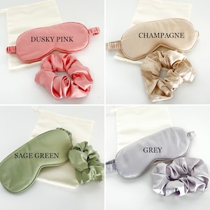 May include: Four sets of silk sleep masks and scrunchies. Each set includes a sleep mask and a scrunchie in a matching color. The colors are Dusky Pink, Champagne, Sage Green, and Grey.