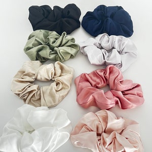 May include: Set of ten satin scrunchies in various colors, including black, green, white, pink, and beige.