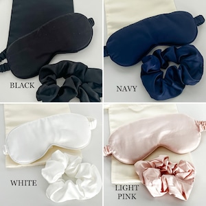 May include: Four sets of silk sleep masks and matching scrunchies in black, navy, white, and light pink.