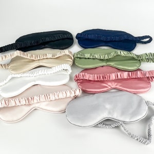 May include: A set of ten silk sleep masks in various colors, including black, navy blue, beige, green, pink, and gray. The masks are all made of soft, smooth silk and have an elastic band that goes around the head.