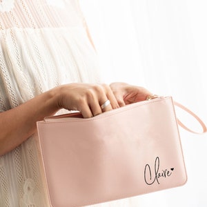 May include: A pink zippered pouch with a black handwritten name "Claire" and a small heart.