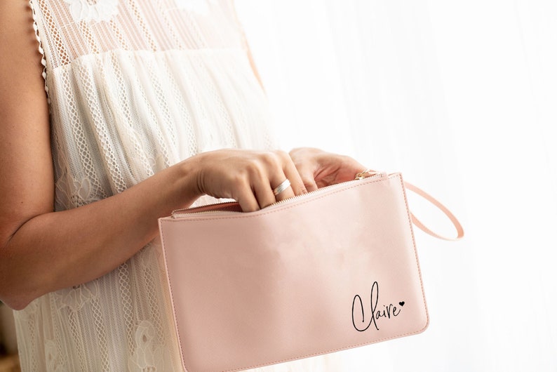 May include: A pink zippered pouch with a black handwritten name "Claire" and a small heart.