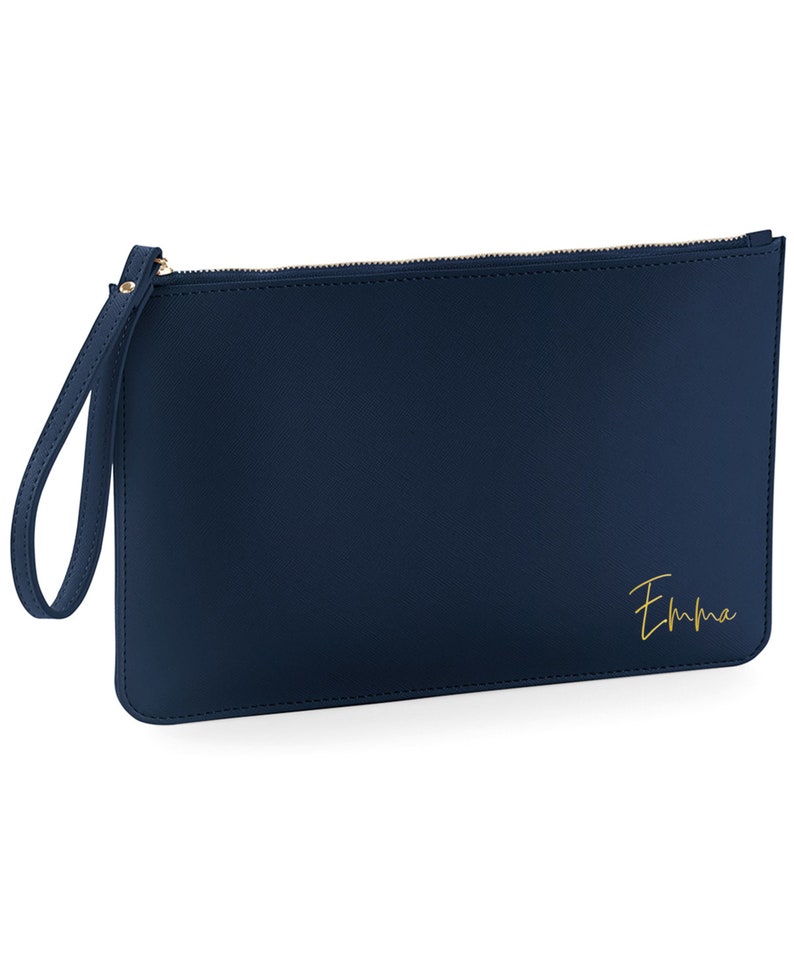 May include: A navy blue zippered clutch with a gold zipper and a gold inscription that reads "Emma".
