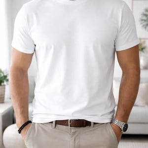 Pode incluir: Uma camiseta branca lisa com gola redonda. A camisa &eacute; combinada com cal&ccedil;as c&aacute;qui e um cinto de couro marrom. Uma pulseira de contas pretas e um rel&oacute;gio prateado s&atilde;o vis&iacute;veis.