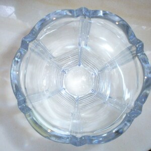 May include: A clear glass vase with a fluted design and a hexagonal base.