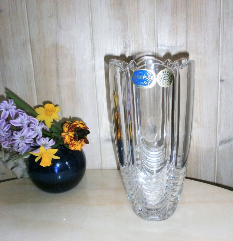May include: A clear glass vase with a textured design and a blue label that reads "Bohemian Crystal Czech Republic".