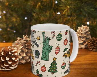 May include: White ceramic mug featuring a repeating pattern of New York City and Christmas-themed illustrations. The design includes the Statue of Liberty, a yellow taxi, Christmas ornaments, a Christmas tree, and a pigeon. The mug has a white handle.