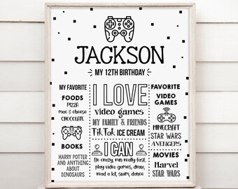 May include: A framed black and white birthday sign with the name "Jackson" and "My 12th Birthday" at the top. The sign lists favorite foods, video games, and interests like "Minecraft" and "Star Wars".
