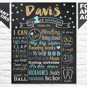 May include: A black chalkboard-style sign with gold glitter text that reads "Davis" and "my 1st birthday." The sign includes facts about the child, such as height (32 inches) and weight (27.5 pounds), and favorite things.