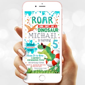 Puede incluir: Un smartphone muestra una colorida invitación de cumpleaños con temática de dinosaurios. La invitación dice: "ROAR, Ven a la fiesta como un dinosaurio, Michael cumple 5 años." El diseño incluye un dinosaurio verde con gafas de sol.