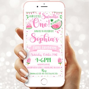 May include: A pink smartphone displays a watermelon-themed first birthday invitation. The invitation features the text "Our Little Sweetie is One!" with watermelon illustrations and details for Sophia's party, including date, time, and location.