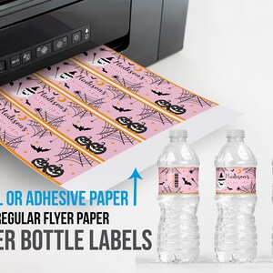 May include: Pink Halloween-themed water bottle labels with a repeating pattern of pumpkins, bats, and spiderwebs. The labels are printed with the text "Madison's 1st Birthday". The labels are shown being printed from a black printer.