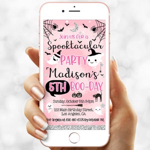 May include: A pink smartphone screen displays a Halloween party invitation. The invitation features a spooky theme with ghosts, bats, and spiderwebs. Text reads "Spooktacular Party" for Madison's 5th Boo-Day, with date, time, and location details.