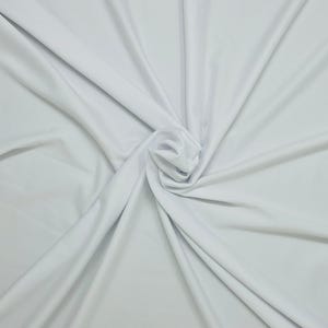 May include: White fabric backdrop with soft, flowing folds. The fabric is smooth and wrinkle-free, creating a clean and elegant background.