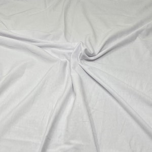 May include: White fabric with soft folds and wrinkles. The fabric is smooth and has a subtle sheen.