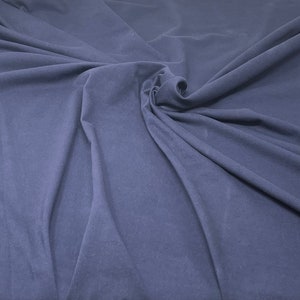 May include: A close-up of a smooth, dark blue fabric with a soft, wrinkled texture.