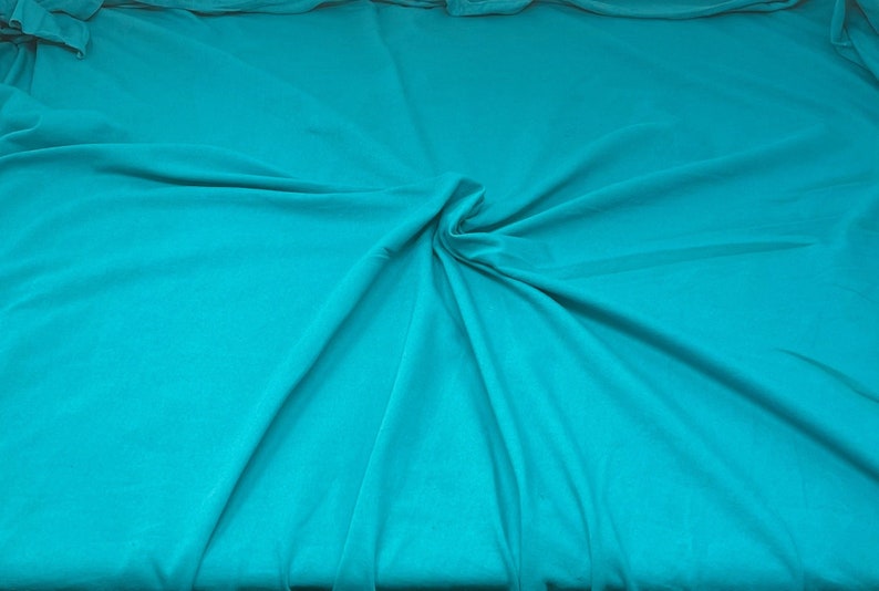 May include: A turquoise fabric backdrop with soft folds and wrinkles.
