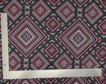 May include: Black fabric with a repeating geometric pattern in shades of pink, white, and gray. The pattern features a diamond shape with a starburst design in the center.