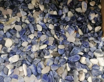 Puede incluir: Una vista cercana de una colección de pequeñas piedras azules y blancas pulidas. Las piedras son lisas y pulidas, y están dispuestas en un patrón aleatorio.