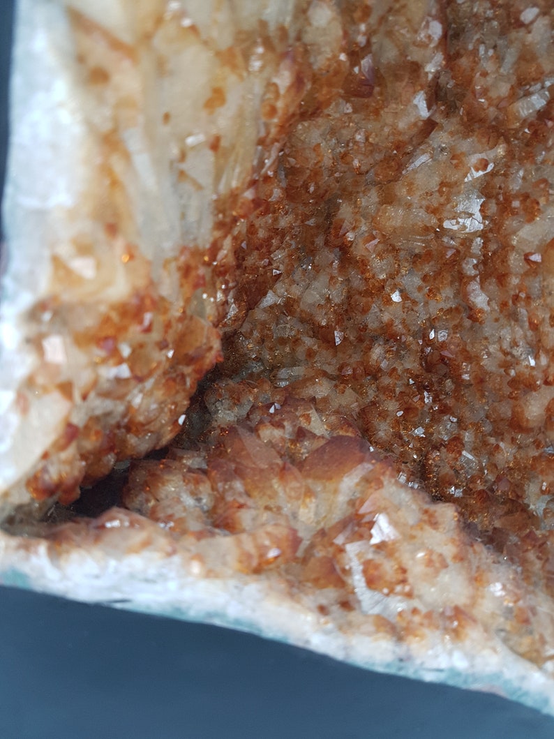 May include: A large, natural crystal geode with a white exterior and a brown, crystal-filled interior. The geode is a natural formation with a rough, textured surface.