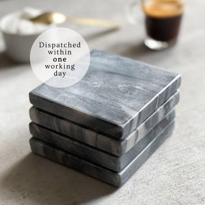 May include: A set of four gray marble coasters with a white marbled pattern. The coasters are stacked on top of each other. The text "Dispatched within one working day" is written on a white circle in the top left corner of the image.