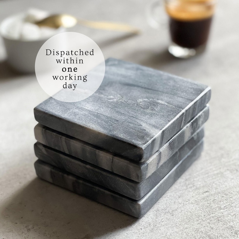 May include: A set of four gray marble coasters with a white marbled pattern. The coasters are stacked on top of each other. The text "Dispatched within one working day" is written on a white circle in the top left corner of the image.