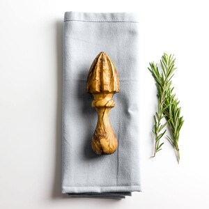 Rustic wooden lemon squeezer, handmade from sustainable olive wood.