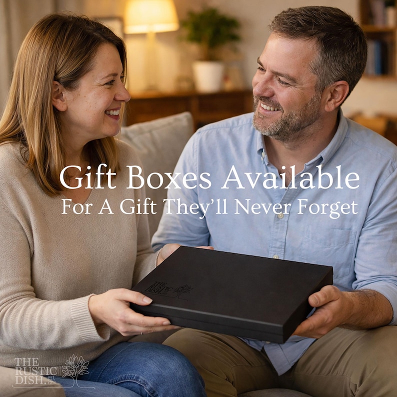 May include: A couple smiling while holding a black gift box. The box has a logo on it and the text "Gift Boxes Available For A Gift They'll Never Forget". The Rustic Dish logo is in the bottom left corner.