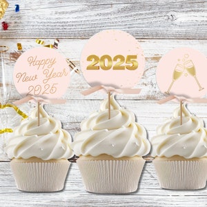 以下が含まれることがあります： ピンクとゴールドのデザインのカップケーキトッパー3つ。トッパーには「Happy New Year 2025」、「2025」、シャンパングラス2つが描かれています。