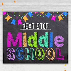 May include: A colorful chalkboard sign with the text "Next Stop Middle School" in a rainbow of colors. The sign is decorated with a string of colorful flags and confetti.