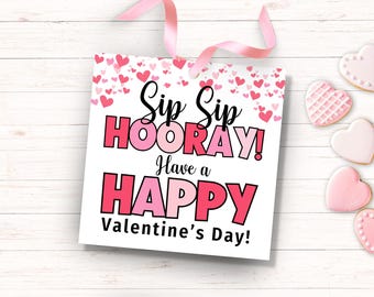 May include: A white card with pink hearts and the text "Sip Sip Hooray! Have a Happy Valentine's Day!"