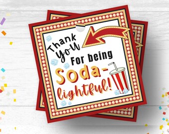 Op de afbeelding: Rood en gouden bedankkaartje met een witte achtergrond en de tekst "Bedankt dat je soda-lightful bent!" met een rode pijl en een rood-wit gestreept sodaglas met een rietje.
