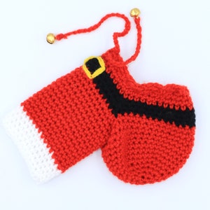 May include: Red and white crocheted Santa Claus stocking with a black belt and gold jingle bells.