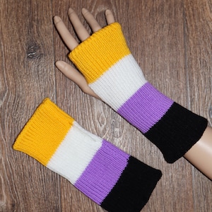 May include: A pair of knitted fingerless gloves with yellow, white, purple, and black stripes. The gloves are made of a soft, warm yarn and are perfect for keeping your hands warm in the winter.